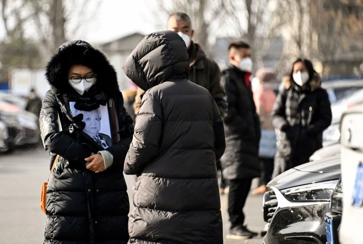 A woman holds a picture frame of a loved one at a crematorium in Beijing on Dec. 20, 2022. (Noel Celis/AFP via Getty Images)