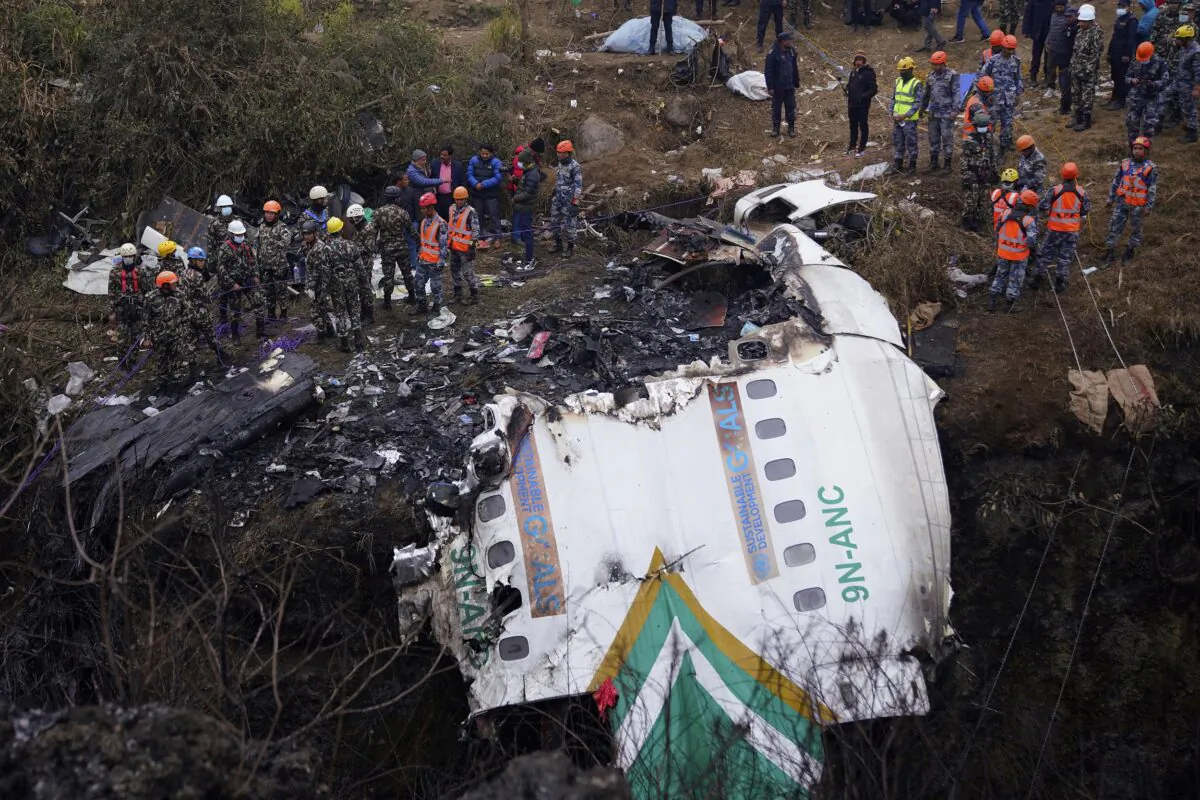Rescuers scour the crash site in the wreckage of a passenger plane in Pokhara, Nepal, on Jan. 16, 2023. (Yunish Gurung/AP Photo)