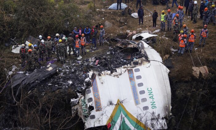 Rescuers scour the crash site in the wreckage of a passenger plane in Pokhara, Nepal, on Jan. 16, 2023. (Yunish Gurung/AP Photo)