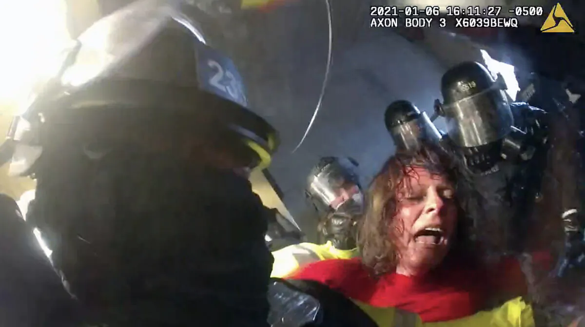 Victoria White is jostled and spun around after being beaten by police in the Lower West Terrace Tunnel at the U.S. Capitol on Jan. 6, 2021. (Metropolitan Police Department/Screenshot via The Epoch Times)