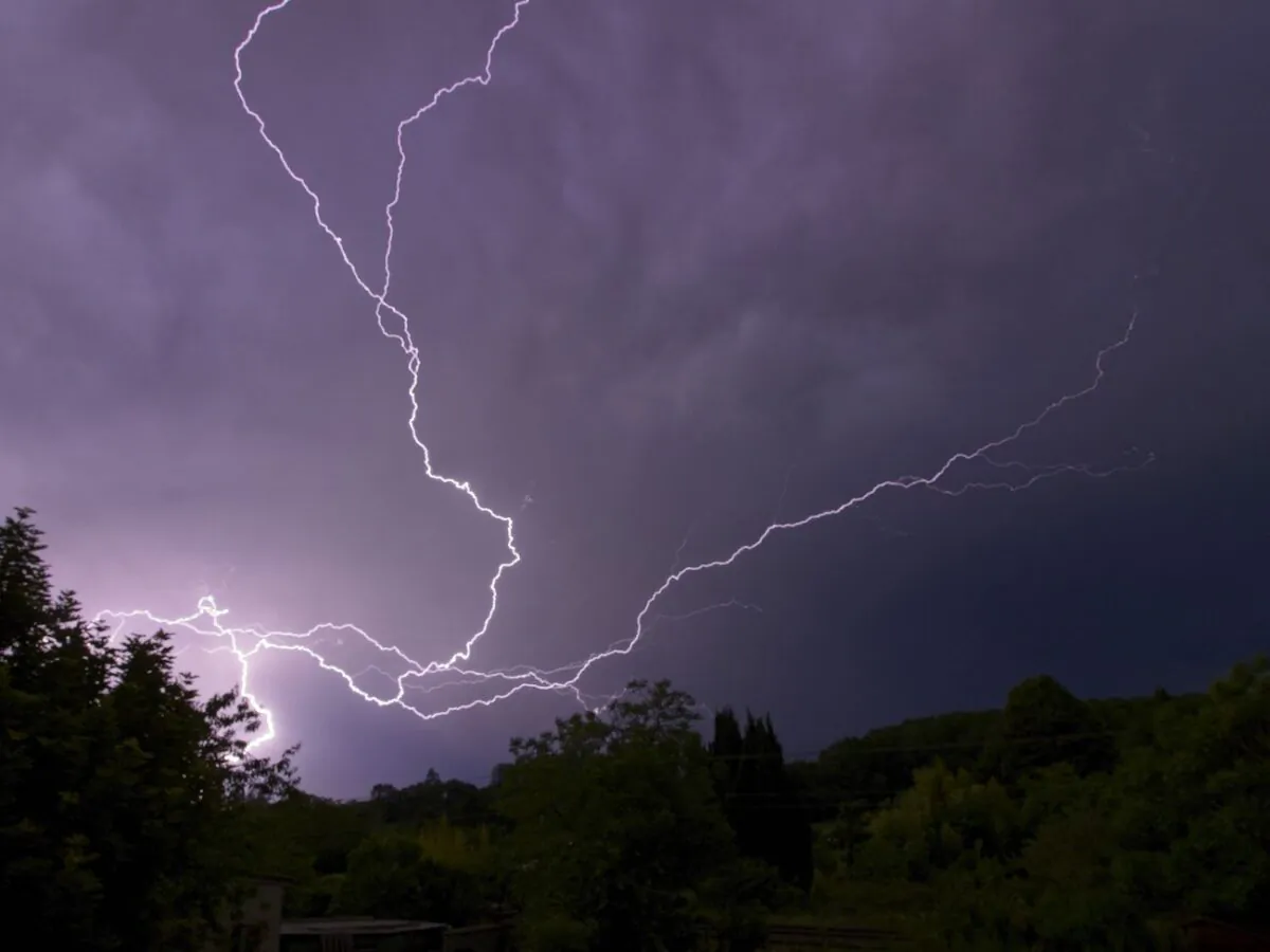Lightning discharges from a thundercloud over trees in Montlouis-sur-Loire, France, on May 22, 2022. (Guillaume Souvant/AFP via Getty Images)