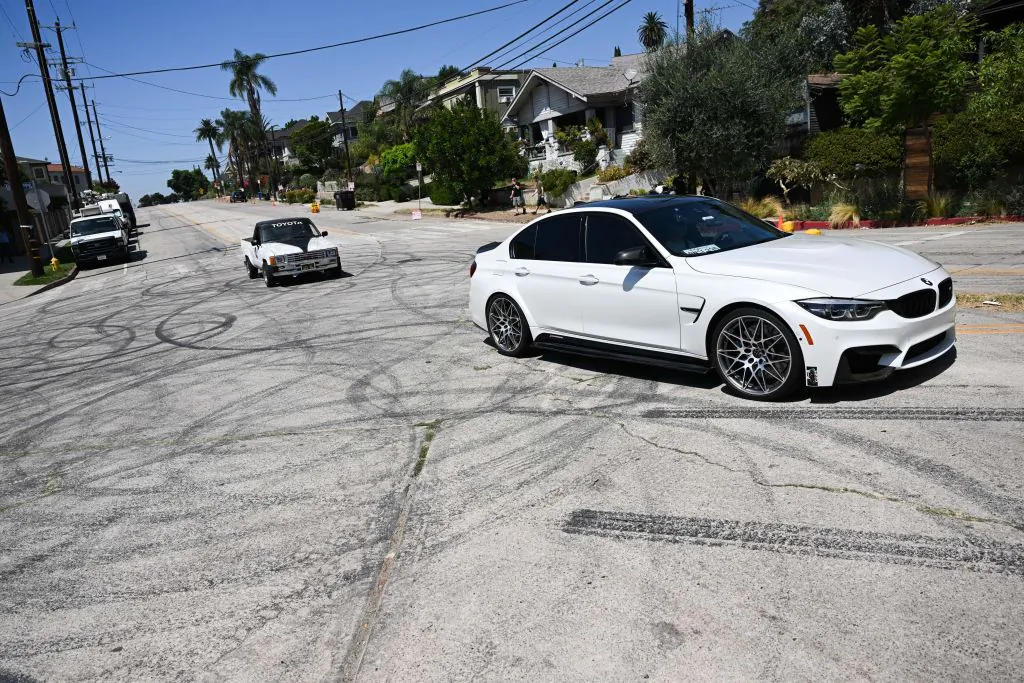 Vehicles drive over tire skid marks from other drivers doing burnouts and "donuts" on Bellevue Ave in Los Angeles, on Aug. 26, 2022. (Patrick T. Fallon/AFP via Getty Images)