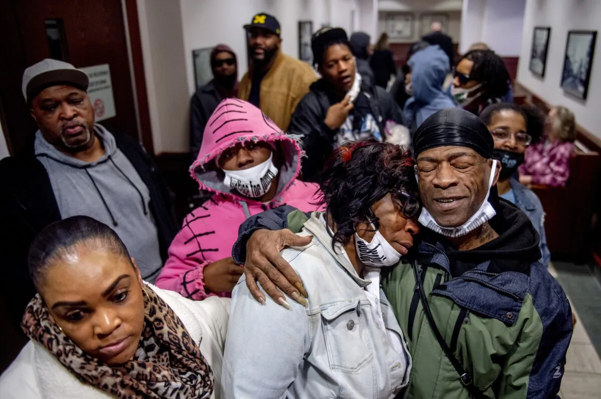 Latryna Sims, partner of Calvin Munerlyn (C), cries on the shoulder of his uncle Ramon Munerlyn as the family celebrates outside the courtroom after Sharmel Teague, her husband Larry Teague, and son Ramonyea Bishop, three defendants charged in the fatal shooting of the security guard at a Family Dollar store in Flint, Mich., were sentenced to life in prison without the possibility of parole in Genesee County Circuit Court on Jan. 17, 2023. (Jake May/MLive.com/The Flint Journal via AP)