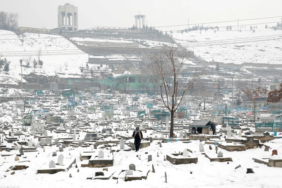 An Afghan man walks on a snow-covered cemetery in Kabul, Afghanistan, on Jan. 11, 2023. (Ali Khara/Reuters)