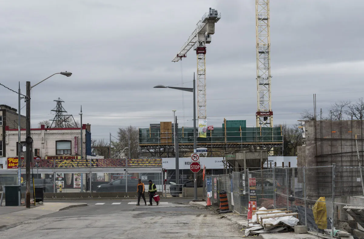 Workers make their way past a construction site in Toronto on April 16, 2021. (THE CANADIAN PRESS/Tijana Martin)