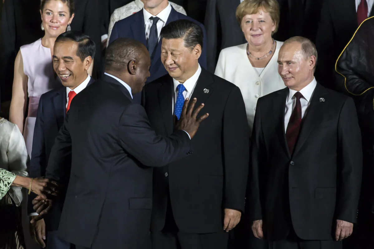 South African President Cyril Ramaphosa (2-L) waves as he walks past Chinese leader Xi Jinping (C) and Russian President Vladimir Putin (R) during a photo session in front of Osaka Castle at the G-20 summit in Osaka, Japan, on June 28, 2019. (Tomohiro Ohsumi/Getty Images)