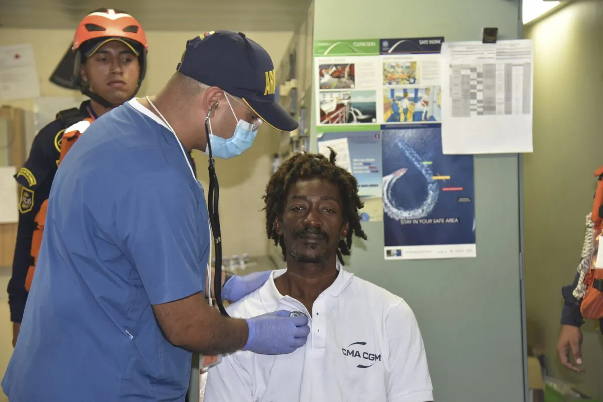 Castaway Elvis Francois is attended by Colombian Navy members after he was rescued near the department of La Guajira, in the extreme north of Colombia, as he sits on board the merchant ship CMA CGM Voltario at the port of Cartagena, Colombia, on Jan. 16, 2023. (Colombian Navy press office via AP)