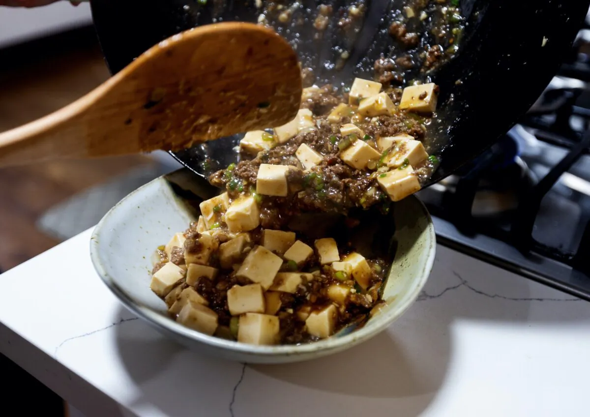 J. Kenji López-Alt, author of “The Wok,” spoons out his recipe “My Mom’s Japanese-Style Mapo Tofu” into a bowl. (Ken Lambert/The Seattle Times/TNS)