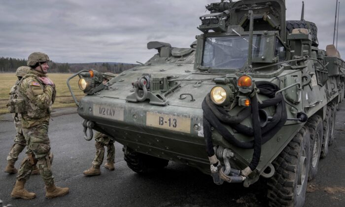 Soldiers of the 2nd Cavalry Regiment stand next to a Stryker combat vehicle in Vilseck, Germany, on Feb. 9, 2022. (Michael Probst/AP Photo)