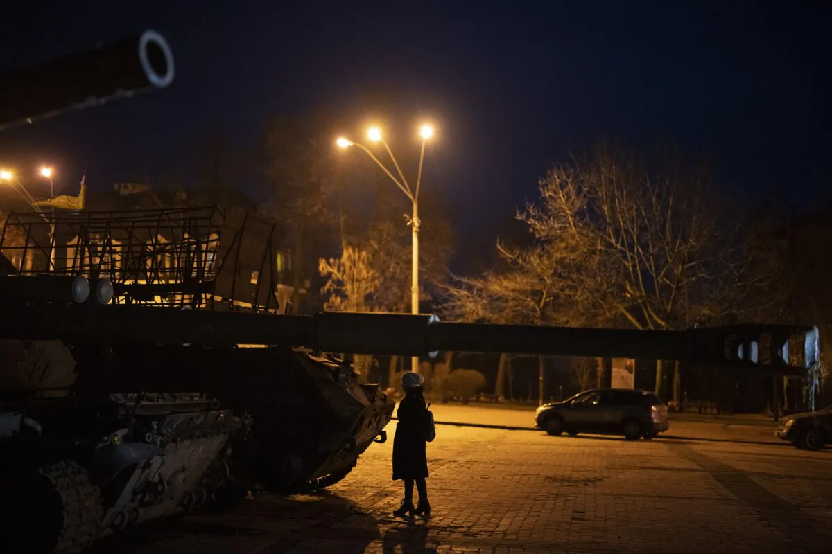 A woman stands in front of a display of destroyed Russian tanks and armoured vehicles in downtown Kyiv, Ukraine, on Jan. 20, 2023. (Daniel Cole/AP Photo)