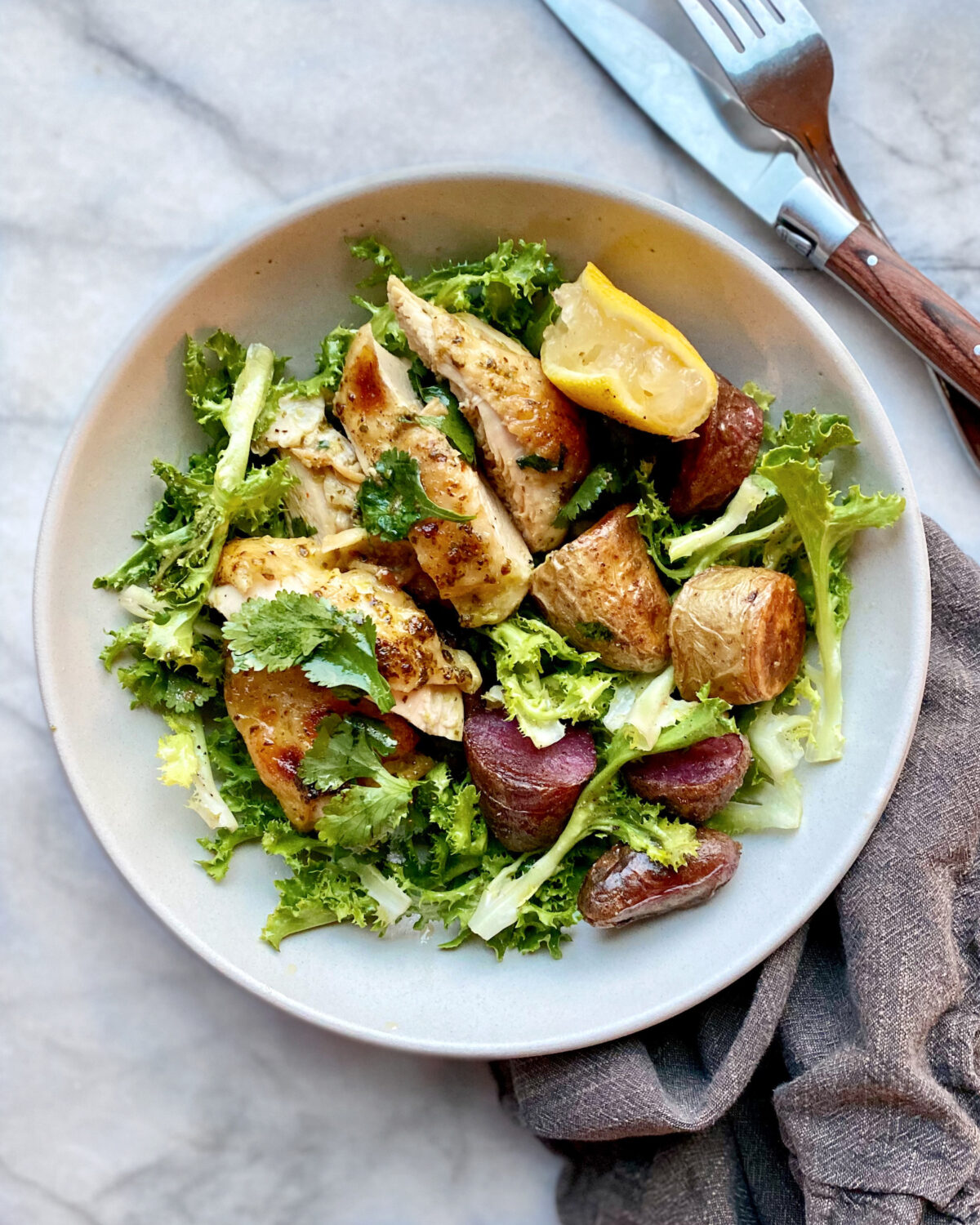 The collected chicken and lemon juices from an easy chicken and potato tray bake become a warm, flavorful dressing for this simple salad. (Lynda Balslev for Tastefood)