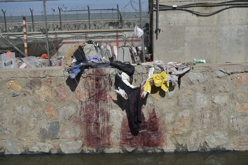 Clothes and blood stains of Afghan people who were waiting to be evacuated at the site of the Aug. 26 twin suicide bombs, which killed scores of people including 13 U.S. troops, at Kabul airport on Aug. 27, 2021. (WAKIL KOHSAR/AFP via Getty Images)