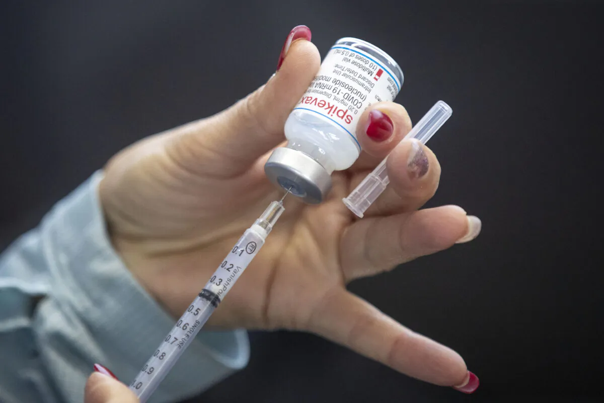 A health worker draws out a Moderna vaccine dose during a drive-through COVID-19 vaccine clinic at St. Lawrence College in Kingston, Ont., on Jan. 2, 2022. (Lars Hagberg/The Canadian Press)