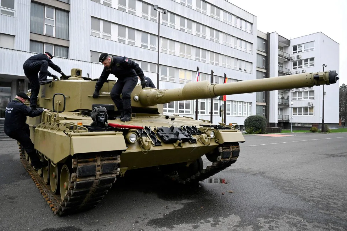 Members of the military walk on a tank, as Germany delivers its first Leopard tanks to Slovakia as part of a deal after Slovakia donated fighting vehicles to Ukraine, in Bratislava, Slovakia, on Dec. 19, 2022. (Radovan Stoklasa/Reuters)