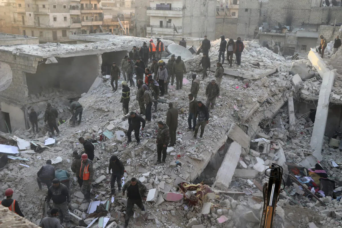 Civil defense workers and civilians work on the rubble of a destroyed building in the Sheikh Maksoud neighborhood in Aleppo, Syria, on Jan. 22, 2023. (Hawar News Agency via AP)