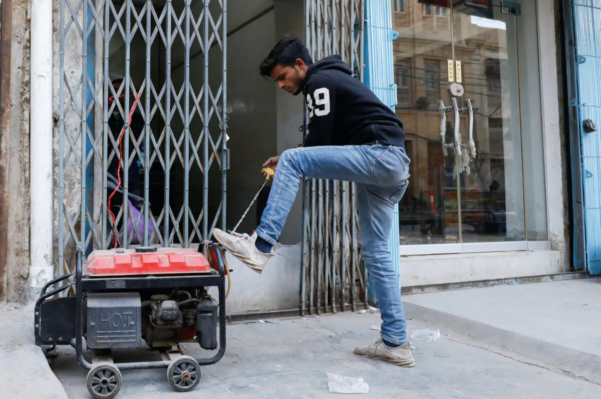 A man starts a gas powered generator in a file photo. (Akhtar Soomro/Reuters)