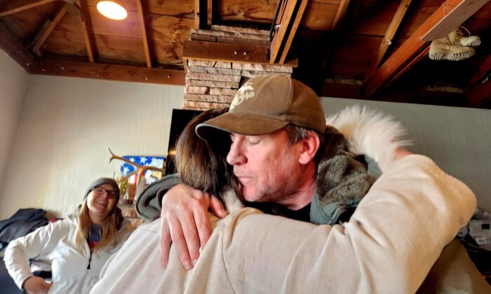 Tom West, co-founder of Operation: Transition Outside The Wire, hugs Juanita Hendrix, wife of a U.S. Army veteran diagnosed with Post Traumatic Stress Disorder, as co-founder Shannon Francis looks on in Williams, Ariz., on Jan. 15, 2023. (Allan Stein/The Epoch Times)