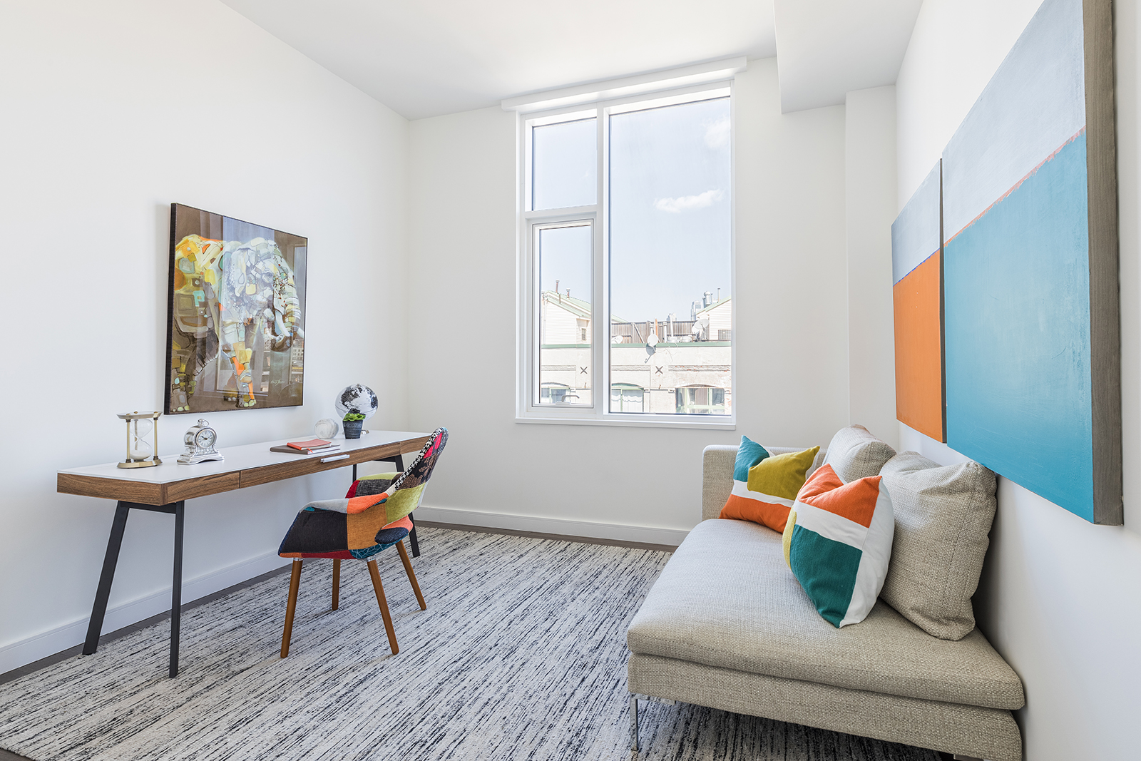 A chaise provides a functional seating option in a modern home office space. 