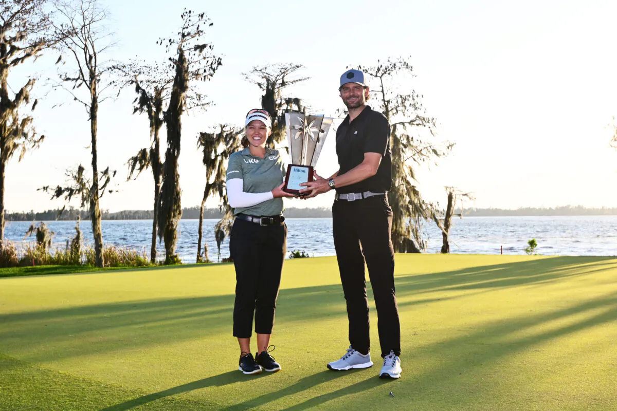 Brooke Henderson of Canada and Mardy Fish of the United States pose with the trophy after winning the Hilton Grand Vacations Tournament of Champions at Lake Nona Golf & Country Club on Jan. 22, 2023 in Orlando, Fla. (Julio Aguilar/Getty Images)
