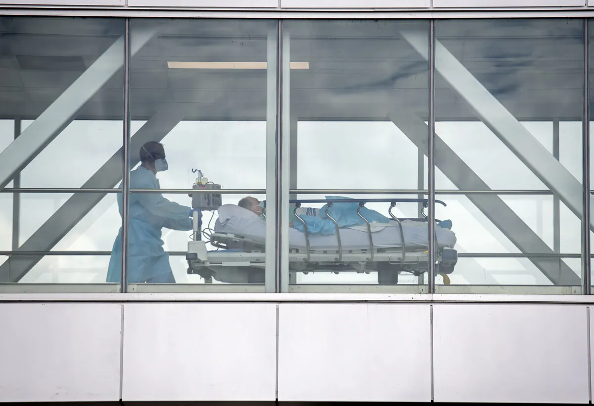 A health-care worker pushes a patient across a connecting bridge at a hospital in Montreal on July 14, 2022. (Graham Hughes/The Canadian Press)