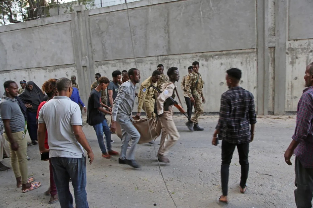 Somalia security carry away the dead body of someone who was killed in clash between attackers and soldiers at the Banadir regional administration in Mogadishu, Somalia, on Jan. 22, 2023. (Farah Abdi Warsameh/AP Photo)