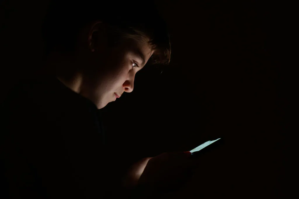A teenage child looks at the screen of a mobile phone in London on Jan. 17, 2023. (Leon Neal/Getty Images)