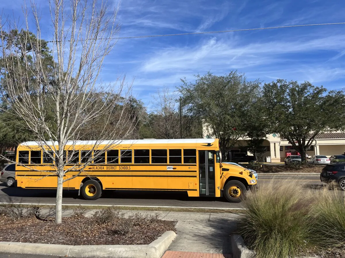 A school bus rolls down the street in Gainesville, Fla., after school on Jan. 23, 2023. (Nanette Holt/The Epoch Times)