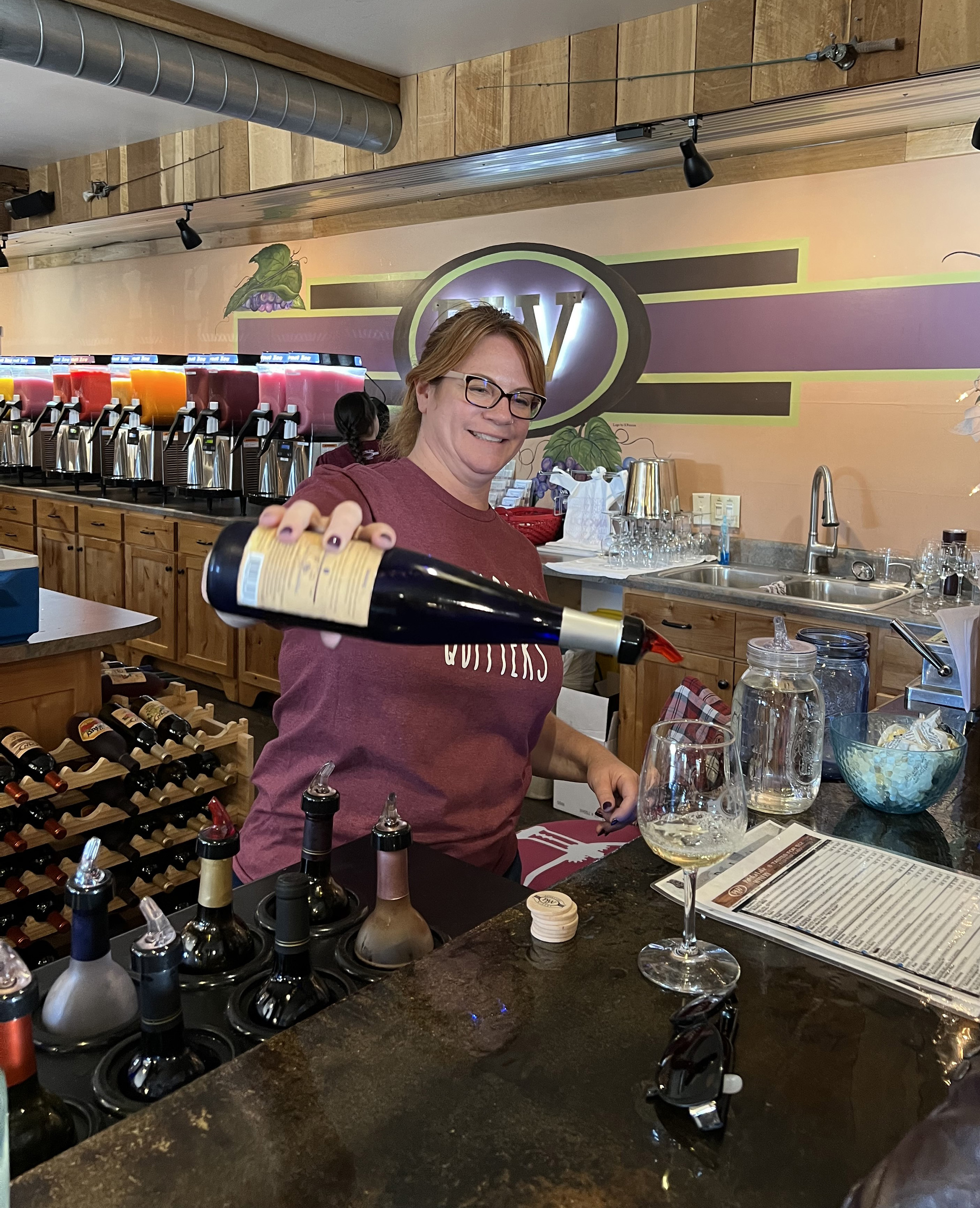 JoLee Kasprzak, one of the managers of Patoka Lake Winery in Birdseye, pours samples of wine for customers.