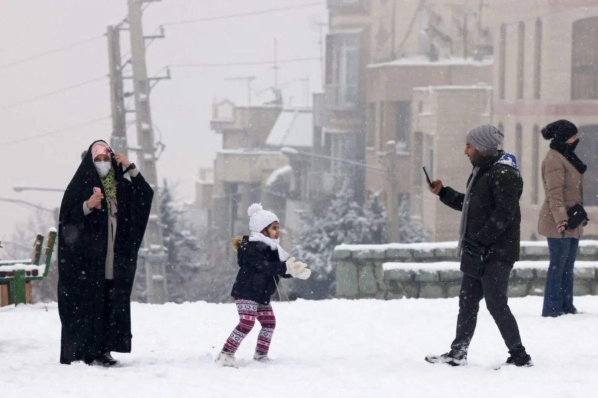 Iranians enjoy a walk in a park during snowfall in the capital Tehran on Jan. 15, 2023. (Atta Kenare/AFP via Getty Images)