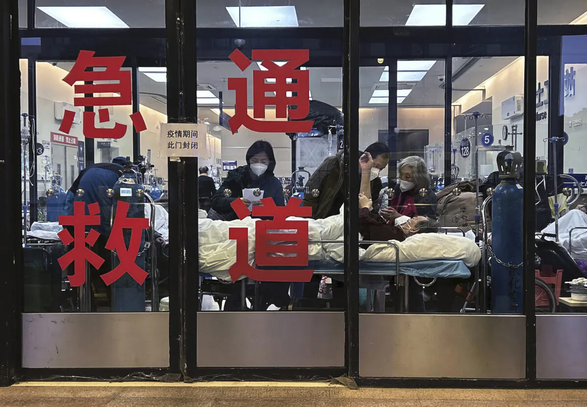 Patients and caregivers are seen in the closed entrance way of an emergency room being used as an overflow area at a hospital in Shanghai, China, on Jan. 14, 2023. (Kevin Frayer/Getty Images)
