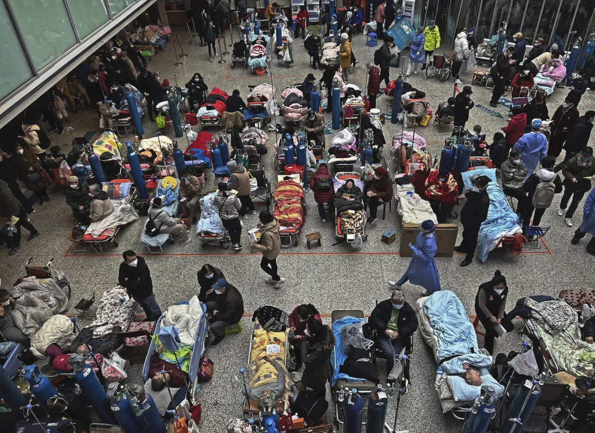 Patients are cared for by relatives and medical staff as they are seen on beds set up in the atrium area of a busy hospital in Shanghai, China, on Jan. 13, 2023. (Kevin Frayer/Getty Images)