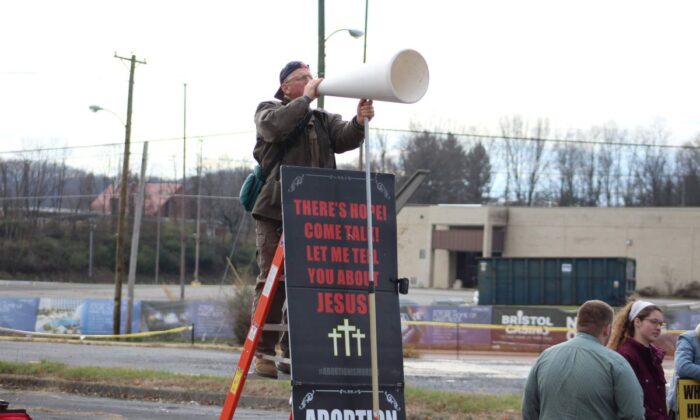 Coleman Boyd stands on a ladder near an abortion facility in Bristol, Va., in December 2022. (Courtesy of Coleman Boyd)
