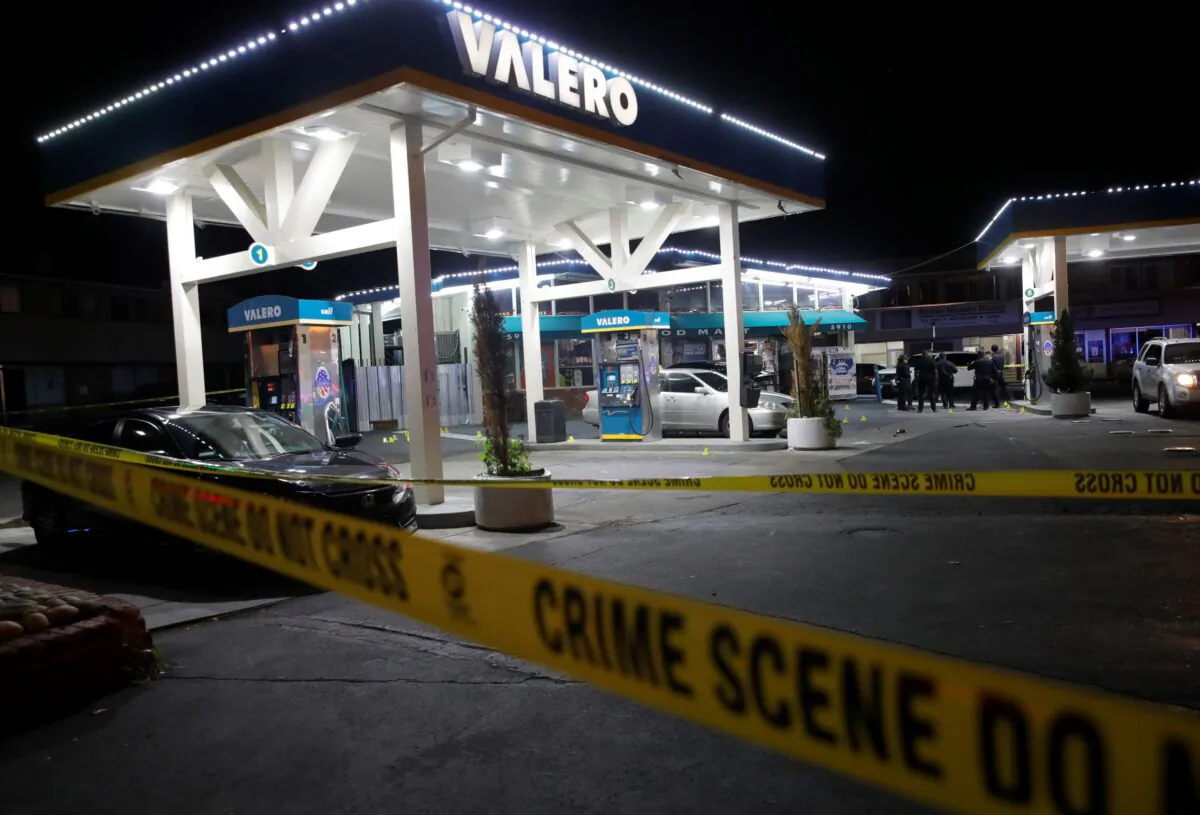 Oakland police investigate a multiple shooting and homicide at the Valero gas station on Seminary Avenue at MacArthur Boulevard in Oakland, Calif., on Jan. 23, 2023. (Jane Tyska/Bay Area News Group via AP)