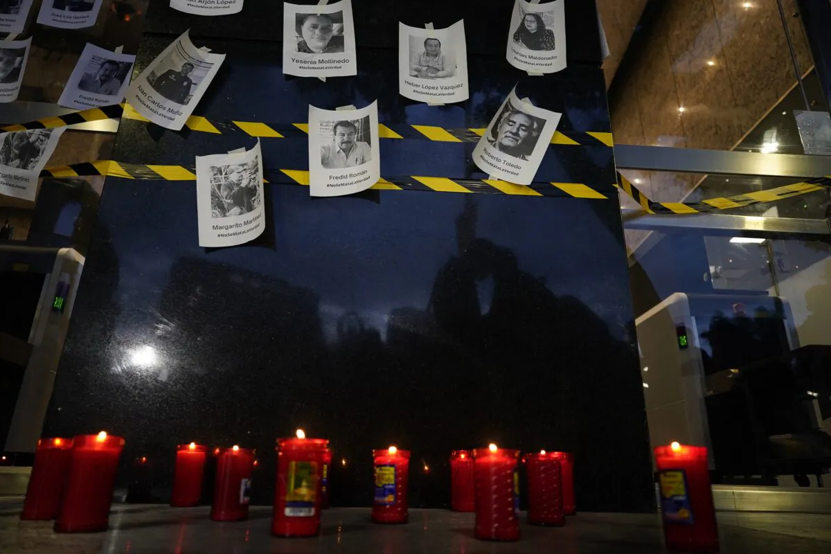 Photos of slain journalists are displayed on a wall during a vigil to protest the murder of journalist Fredid Roman, outside Mexico's Attorney General's office in Mexico City on Aug. 24, 2022. (Eduardo Verdugo/AP Photo)