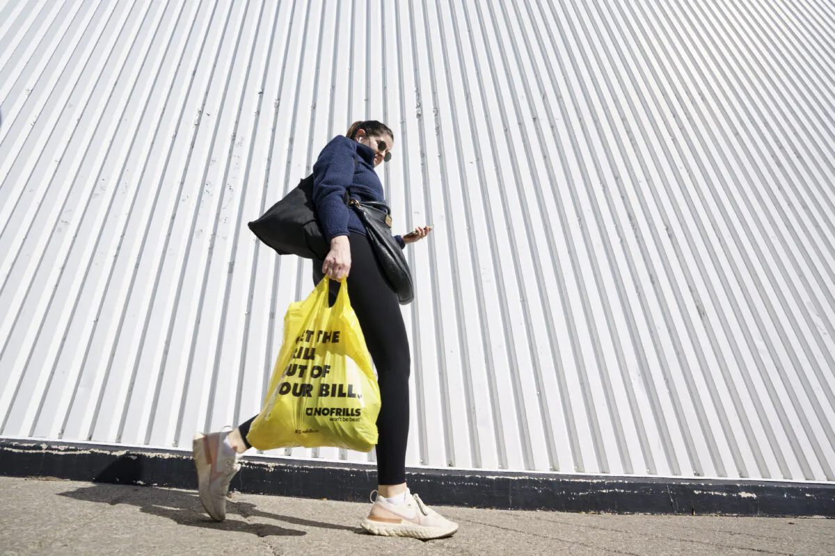 A person leaves a Toronto supermarket with groceries on Oct. 5, 2022. (Alex Lupul/The Canadian Press)
