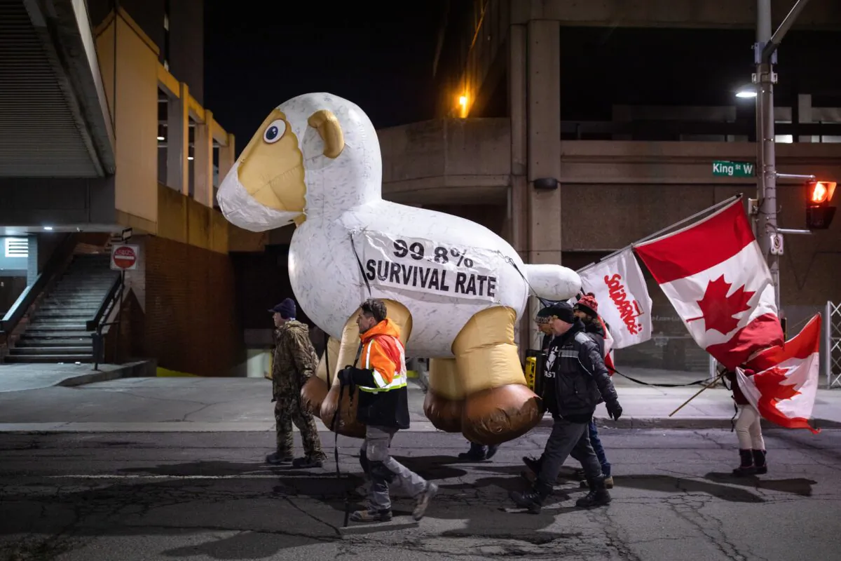 Protesters walk with an inflatable sheep in downtown Hamilton, Ont., where the Liberal Cabinet retreat was taking place, on Jan. 24, 2023. (Nick Iwanyshyn/The Canadian Press)