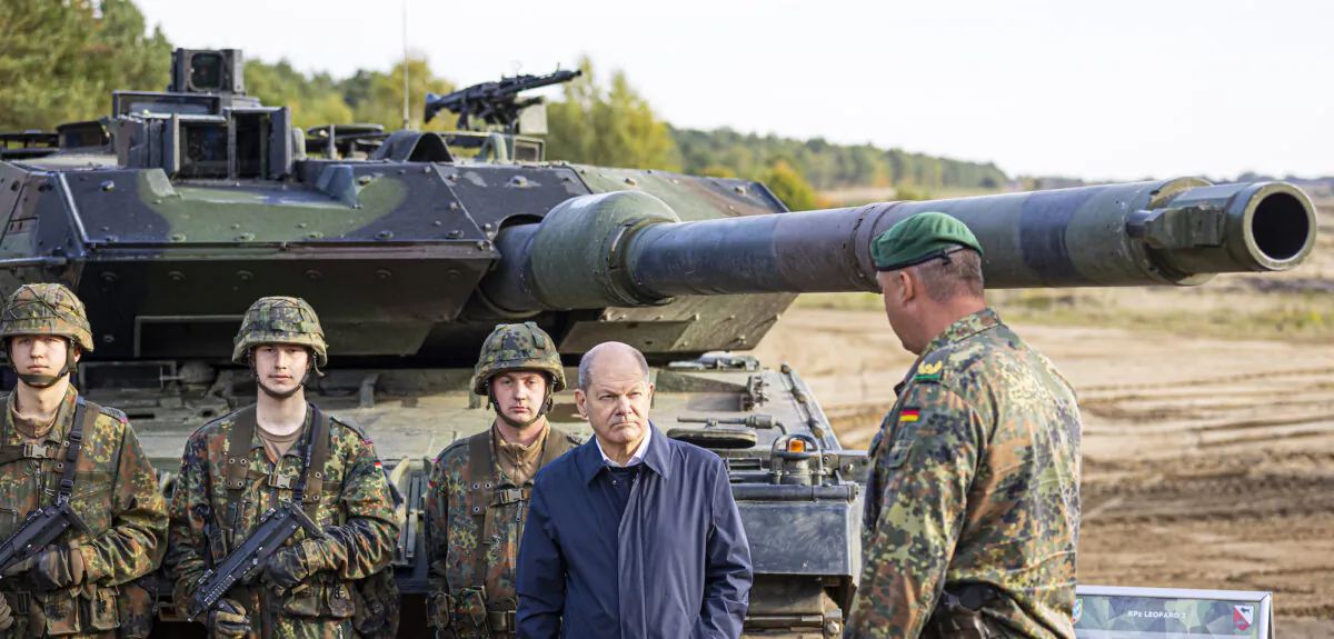 German Chancellor Olaf Scholz stands with German army Bundeswehr soldiers at a Leopard 2 main battle tank during a training and instruction exercise in in Ostenholz, Germany, on Oct. 17, 2022. (Moritz Frankenberg/dpa via AP, File)