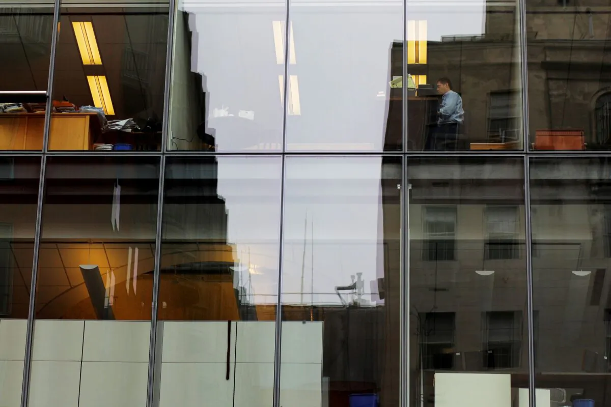 A worker sits at his desk in an office building in Washington on Aug. 3, 2018. (Brian Snyder/Reuters)