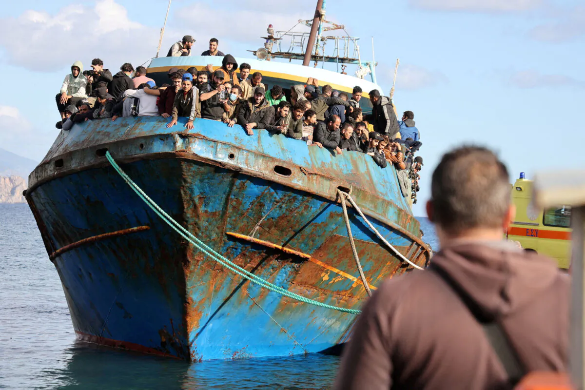 Migrants stand onboard a fishing boat at the port of Paleochora, following a rescue operation off the island of Crete, Greece, on Nov. 22, 2022. (Stringer/Reuters)