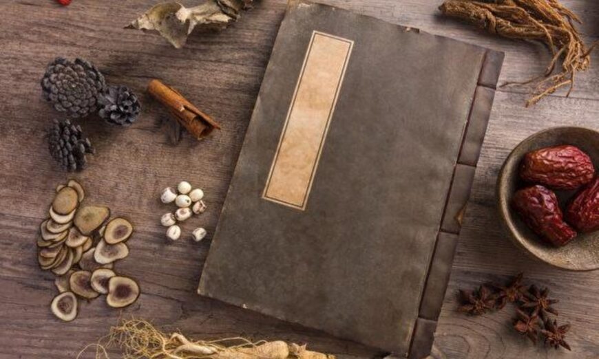 Various Chinese medicinal herbs and a traditional thread-bound book. (Shutterstock)