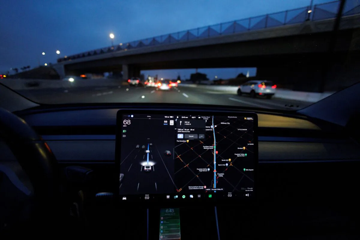 A Tesla Model 3 vehicle drives on autopilot along the 405 highway in Westminster, Calif., on March 16, 2022. (Mike Blake/Reuters)