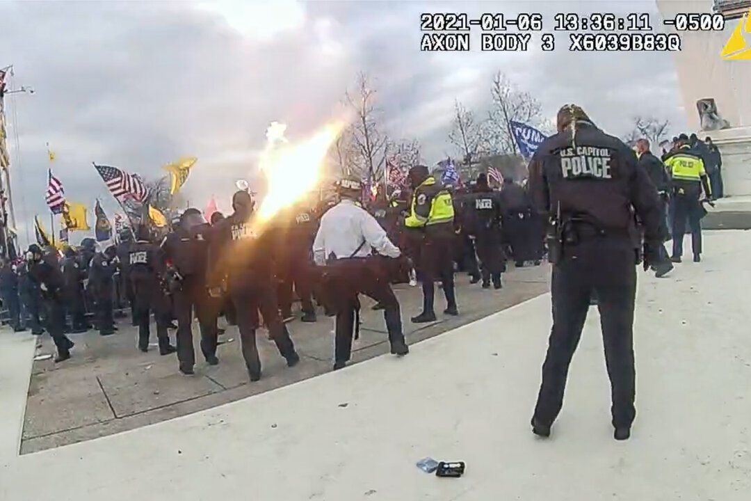 A grenade tossed by D.C. Metropolitan Police Officer Daniel Thau explodes over the heads of protesters at the U.S. Capitol on Jan. 6, 2021. (Metropolitan Police Department/Screenshot via The Epoch Times)