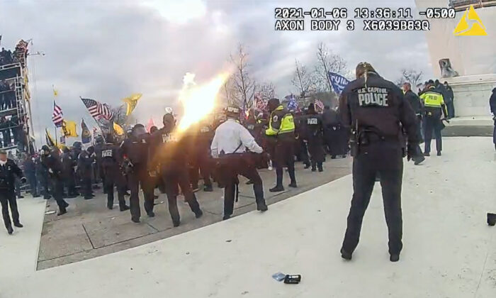 A grenade tossed by D.C. Metropolitan Police Officer Daniel Thau explodes over the heads of protesters at the U.S. Capitol on Jan. 6, 2021. (Metropolitan Police Department/Screenshot via The Epoch Times)