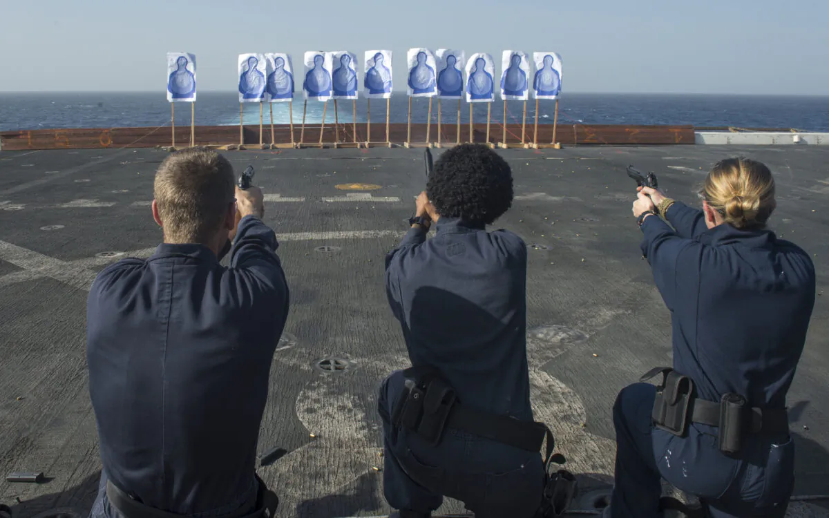 Sailors assigned to amphibious transport dock ship USS San Diego (LPD 22) fire 9mm handguns from the kneeling position during a live-fire exercise on the flight deck of the ship. (U.S. Navy Mass Communication Specialist 2nd Class Stacy M. Atkins Ricks)