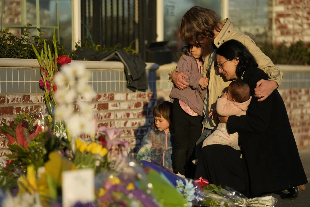 A family gathers at a memorial outside the Star Ballroom Dance Studio in Monterey Park, Calif.,  on Jan. 24, 2023. (Ashley Landis/AP Photo)