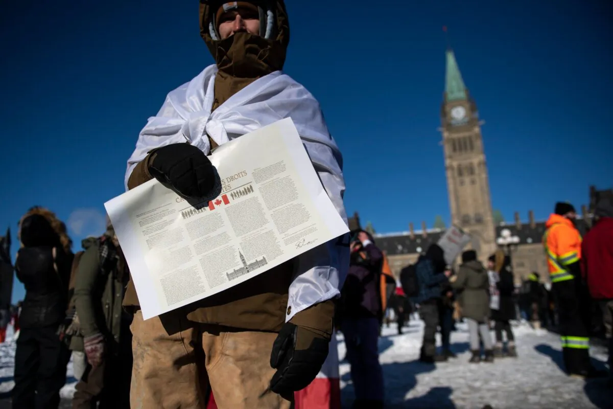 A file photo of a protester holding the Charter of Rights and Freedoms during a rally against COVID-19 restrictions on Parliament Hill in Ottawa, on Jan. 29, 2022. (Justin Tang/The Canadian Press)