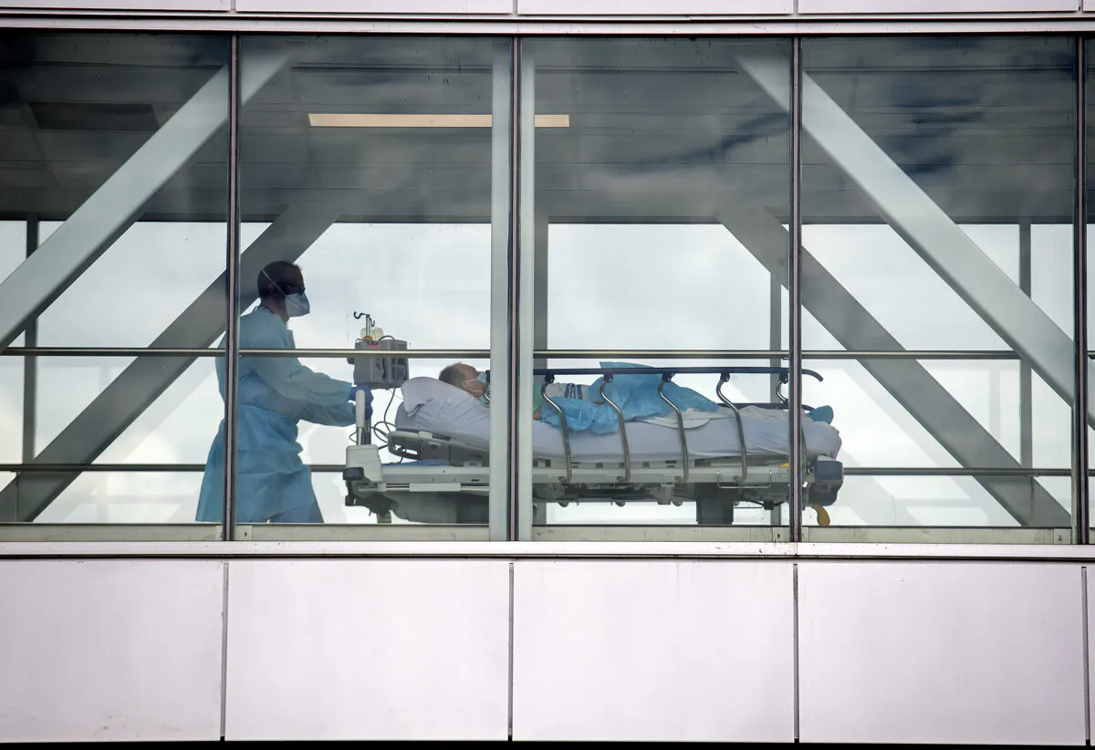 A health-care worker pushes a patient across a connecting bridge at a hospital in Montreal on July 14, 2022. (Graham Hughes/The Canadian Press)