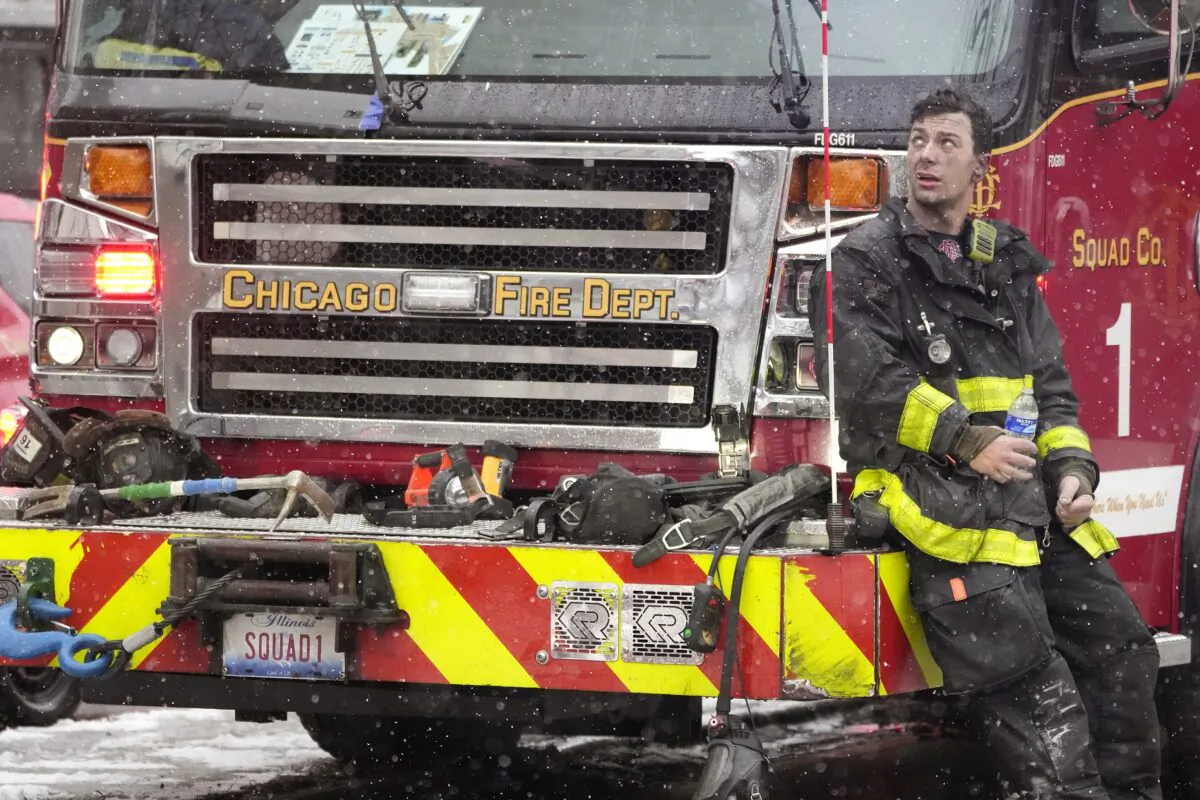 Chicago Firefighter Mose Demasi looks up at the Harper Square cooperative residential building after he and others fought a multi-floor fire at the high-rise in the Kenwood neighborhood of Chicago on Jan. 25, 2023. (Charles Rex Arbogast/AP Photo)