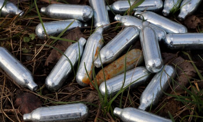 Nitrous oxide canisters discarded by the roadside in Ebbsfleet, England, in January 2020. (PA)