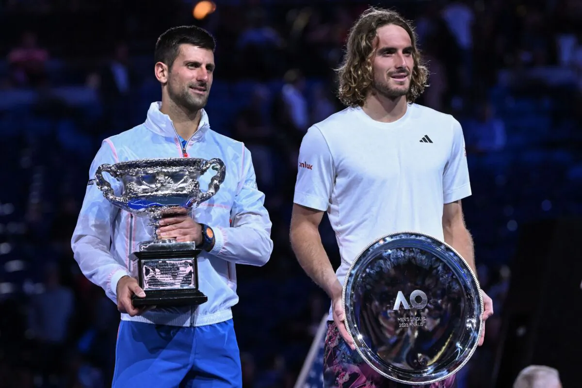 Serbia's Novak Djokovic (L) holding the Norman Brookes Challenge Cup poses with Greece's Stefanos Tsitsipas (R) afer his victory during the men's singles final on day 14 of the Australian Open tennis tournament in Melbourne on Jan. 29, 2023. (William West/AFP via Getty Images)
